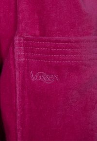 Fuchsia Bademantel aus strukturiertem Samtstoff, mit dezentem eingesticktem Logo und einer genähten Taschenapplikation.