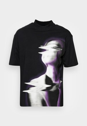 T-shirt noir à col haut, arborant un graphisme déformé d'un visage en niveaux de gris et teintes violettes, ajoutant de la profondeur et de la texture.