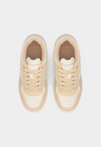 Ζευγάρι μπεζ και κρεμ αθλητικών παπουτσιών Champion με κορδόνια, απεικονιζόμενα από πάνω σε λευκό φόντο.