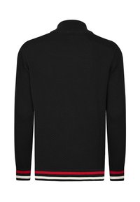 Suéter de punto negro con un patrón texturizado, cuello alto y mangas largas. Presenta acentos a rayas en rojo, blanco y negro en los puños y el dobladillo.