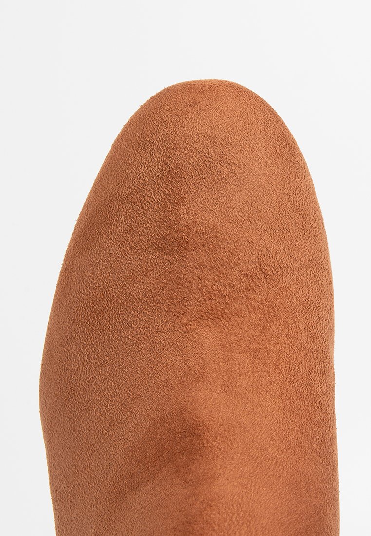 Braune Wildleder-Ankle-Boots mit einer abgerundeten Zehenpartie. Die Oberfläche zeigt eine weiche Textur mit feinen Farbvariationen.