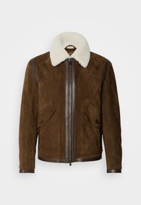 Veste en daim marron avec col en peau lainée blanche, fermeture éclair à l'avant, poches à rabat boutonnées et garniture en cuir sur les épaules et les poignets.