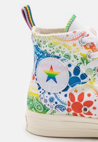 Baskets montantes Converse avec motifs cachemire arc-en-ciel, patch logo étoile arc-en-ciel et languette arc-en-ciel au talon.