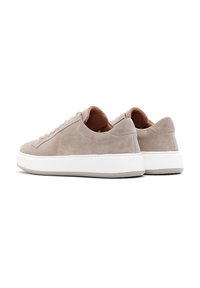 Sneakers beige in suede con suola in gomma bianca, design low-top, lacci piatti e stile minimalista. Nessun motivo o accento prominente.