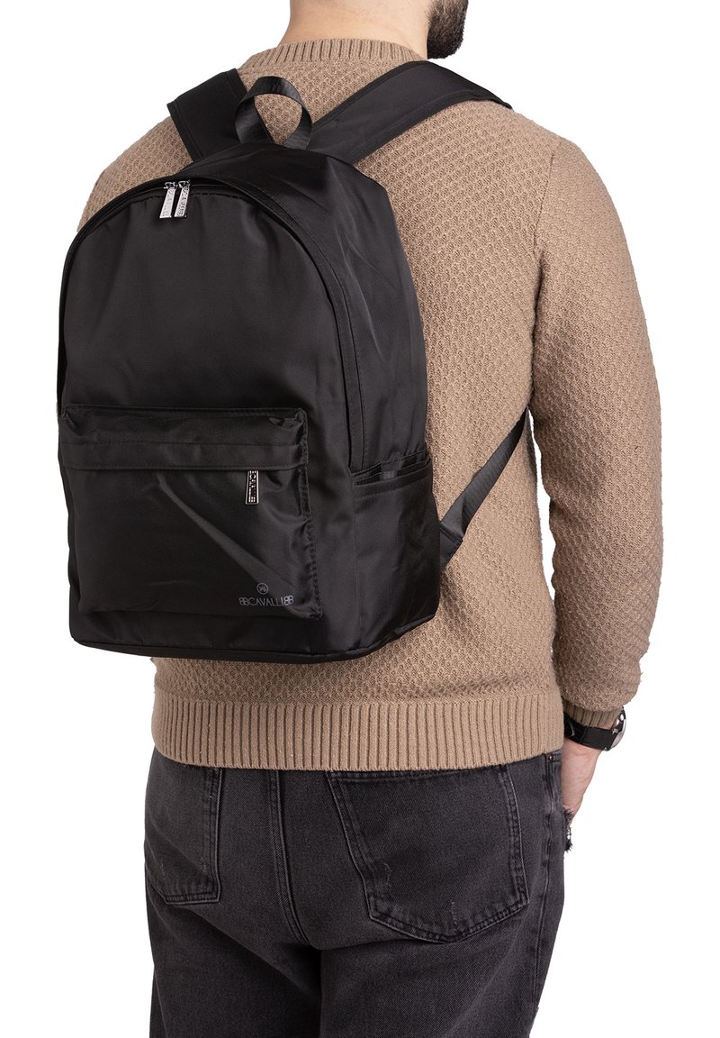 Zaino in nylon nero con un compartimento principale, tasca frontale con zip e spallacci regolabili. Presenta linee pulite e minimalismo nel marchio.