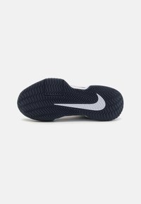 Nike sportssko sål i sort gummi med fiskebensmønster, prydet med et hvidt swoosh-logo og en tekstureret overflade for bedre greb.