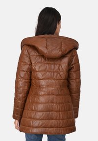 Chaqueta de plumas de cuero marrón con capucha, con textura acolchada y silueta ajustada. Las mangas tienen un acabado suave.