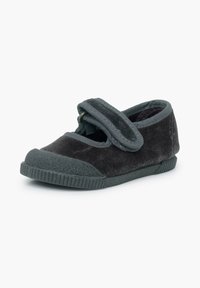 Zapato infantil de terciopelo negro con punta redonda, suela de goma texturizada y una correa de Velcro en la parte superior para su ajuste.