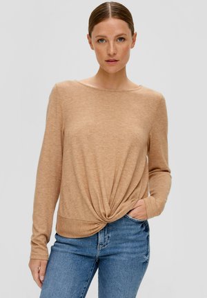 Lichtbeige, lange mouw gebreid top met een ronde hals en gedraaide voorkant, gecombineerd met blauwe denim jeans. Zachte textuur, casual pasvorm.