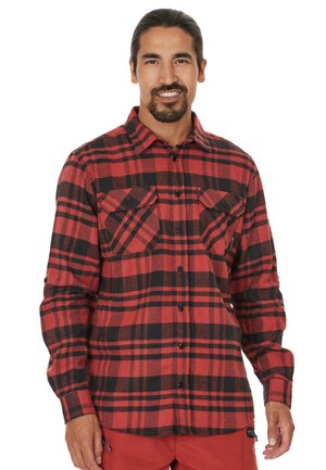 Chemise en flanelle à carreaux rouges et noirs avec des manches longues, deux poches poitrine et un bouton-avant. Fabriquée en tissu doux et texturé.