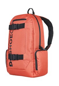 Oranžový látkový batoh s černými detaily, s nastavitelnými popruhy, sponou na zavírání a boční kapsou na zip. Textový logo na přední straně.