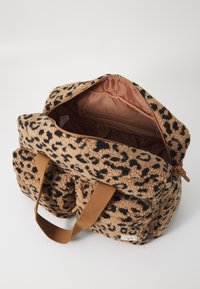 Mochila de pelúcia com padrão de leopardo, alças castanhas, abertura com fecho e um bolso interior. Textura macia com uma palete de cores em bege e preto.