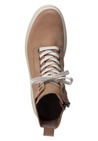 Zapatilla alta de cuero marrón con cordones blancos, forro interior negro y un zipper lateral. Presenta un collar texturizado y suela de goma blanca.