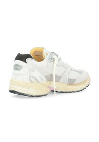 Sneaker blanche avec une surface texturée, des accents gris, un talon noir et un détail rose sur la semelle. Design lacé, col rembourré.