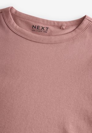 Långärmad t-shirt i dammrosa, tillverkad av mjuk bomull, med en enkel rund halsringning och en slät textur. Etiketten säger "NEXT."