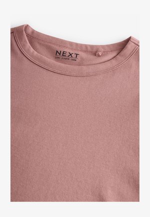 Långärmad t-shirt i dammrosa, tillverkad av mjuk bomull, med en enkel rund halsringning och en slät textur. Etiketten säger "NEXT."