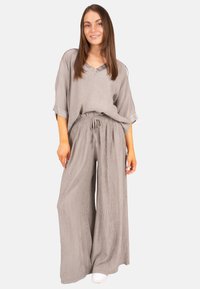 Ensemble deux pièces gris clair comprenant un haut ample avec un col en V et un pantalon large. Tissu texturé avec une taille élastique. Design simple.