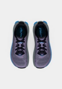 Zapatillas para correr por senderos de color púrpura con parte superior de malla, cordones negros y detalles en azul. Cuenta con una suela acolchada y un diseño perforado para mayor transpirabilidad.