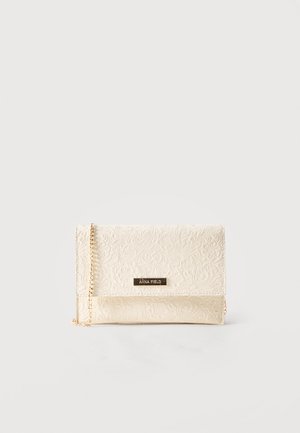 Crème kleurige clutch met geperst bloemmotief, gouden kettingriem en een klein metalen plaatje met de tekst "ANNA FIELD" op de voorklep.