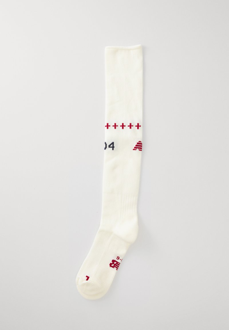 Meias brancas até ao joelho com textura canelada, apresentando elementos decorativos em vermelho e números, confeccionadas em material elástico e respirável.
