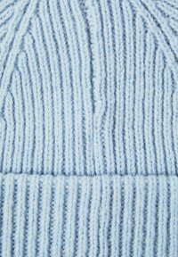 Ljust blåk knitted mössa med vertikala ribbmönster, som har en mjuk textur och en vikbar kant i botten för extra värme.