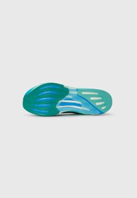 Sole di scarpa sportiva verde e blu in gomma testurizzata per una migliore aderenza, con numerose scanalature e una sezione traslucida vicino al tallone.