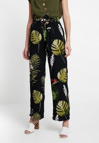 Svarta, vida byxor med ett tropiskt bladdesign i grönt och vitt. Tyget är lätt och har en knytning i midjan.