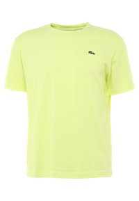 Tričko s krátkým rukávem v fluorescentní žluté barvě vyrobené z bavlny. Design s kulatým výstřihem a malým černým logem na levé hrudi. Hladká textura.
