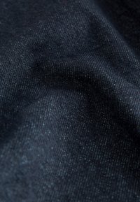 Tessuto blu scuro con una superficie morbida e testurizzata, caratterizzato da un motivo sottile e una tessitura fine e uniforme. Adatto a varie applicazioni tessili.