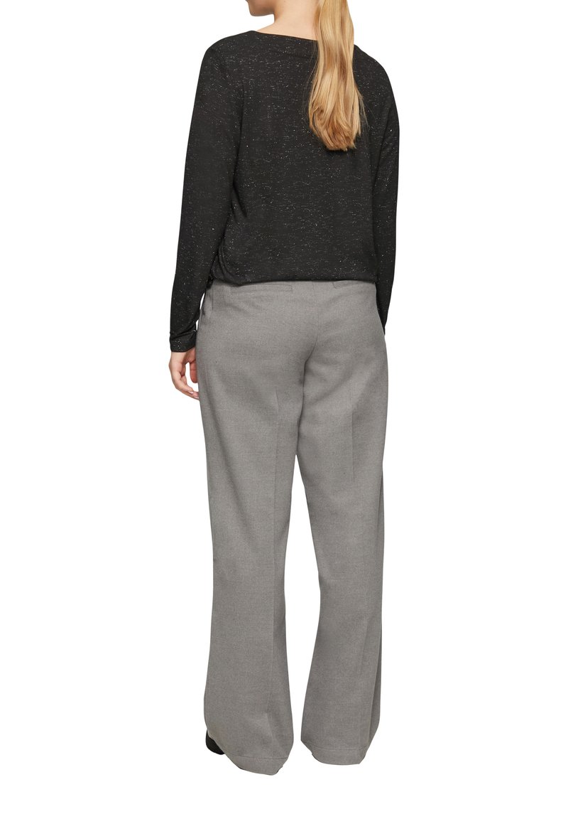 Schwarzes Langarmshirt mit strukturierten Finish, kombiniert mit hellgrauen, weit geschnittenen Hosen; beide zeichnen sich durch ein einfaches, klassisches Design aus.