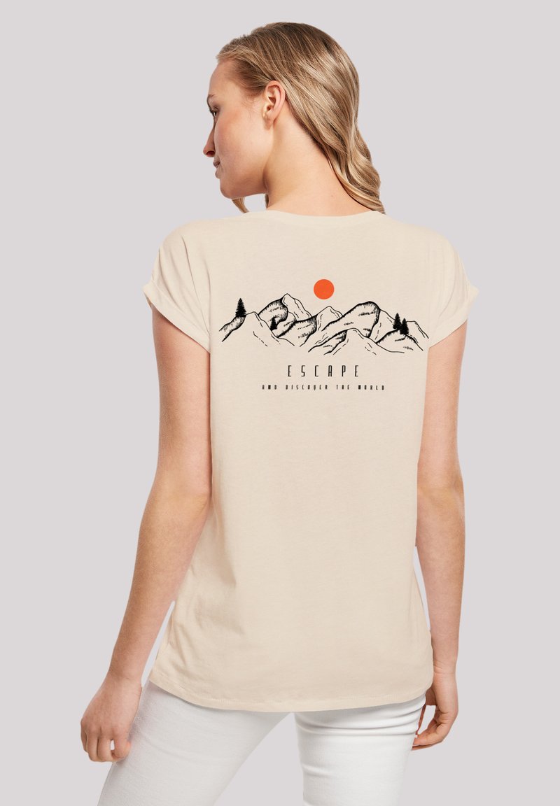 Cream-colored cotton t-shirt featuring a graphic of mountains and a sun on the back, with the word "ESCAPE" in black text beneath.