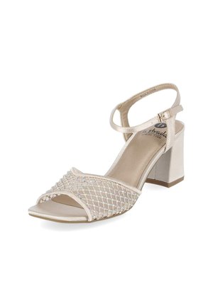 Beżowy sandał na słupku z odkrytymi palcami, pasek wokół kostki, zapięcie na klamrę oraz opalizująca siateczka z koralikami na obszarze palców.