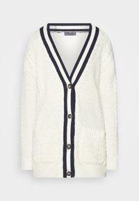 Cárdigan blanco de punto con acentos en azul marino, cuello en V, cinco botones, dos bolsillos frontales y patrón de punto trenzado texturizado.