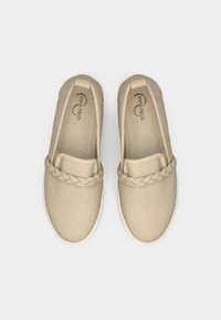 Beige canvas slip-on shoes with a braided accent across the front, white rubber sole, and padded insole labeled "Memory Foam."