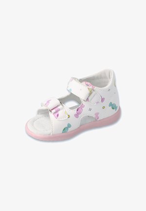 Białe sandały z różową podeszwą, ozdobione wzorami w tematyce cukierkowej w pastelowych kolorach. Wykonane z materiału syntetycznego, z dwiema regulowanymi paskami na rzepy.