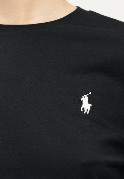 Μαύρο μπλουζάκι με στρογγυλή λαιμόκοψη και μικρό λευκό κέντημα με το λογότυπο ενός παίκτη πόλο επάνω σε άλογο στο στήθος.