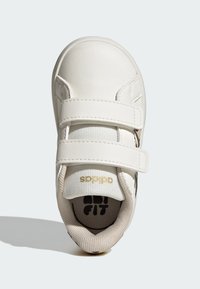 Sneaker bianca con esterno in pelle liscia, due strisce in Velcro, parte superiore testurizzata, colletto imbottito e logo stampato nella soletta.