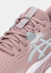 Rosa treningssko med mesh-overdel, kontrasterende grå detaljer, runde lisser og perforert design for pusteevne. Merkevarelogo er inkludert.