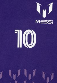 Μωβ μπλούζα με λευκό κείμενο "MESSi" και αριθμό "10", με επαναλαμβανόμενο γραφικό μοτίβο σε φωτεινότερη απόχρωση του μωβ στο κάτω μέρος.