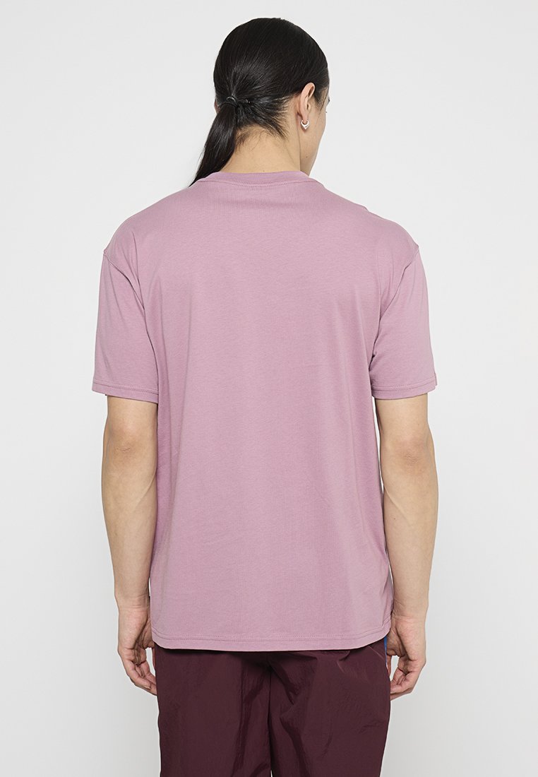 Koszulka z krótkim rękawem w jasnym mauve, o dekolcie typu crew neck, wykonana z miękkiego materiału, o gładkiej fakturze. Brak widocznego logo z tyłu.