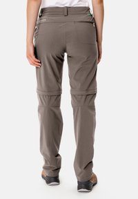 Graue Convertible-Hiking-Hosen mit einer lässigen Passform, elastischem Bund und einem Reißverschluss-Rückentasche; entworfen für Vielseitigkeit bei Aktivitäten im Freien.