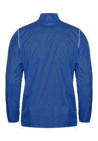 Giacca a vento leggera blu con colletto alto, maniche lunghe e polsini elasticizzati. Presenta una texture liscia e un design minimalista.