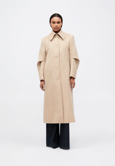 Beige wool coat with a large collar and five-button front closure, featuring wide sleeves and a long, straight silhouette.