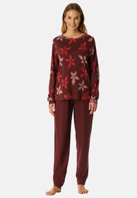 Bordeaux pyjama-set met een lange mouw top met een bloemenpatroon in tinten van rood en roze, gecombineerd met bijpassende losse broek.