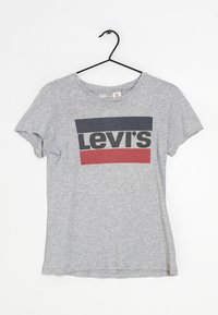 Šedé tričko s krátkým rukávem a kulat�ým výstřihem, s tištěným logem Levi's v černé, námořnické a červené barvě přes hruď.