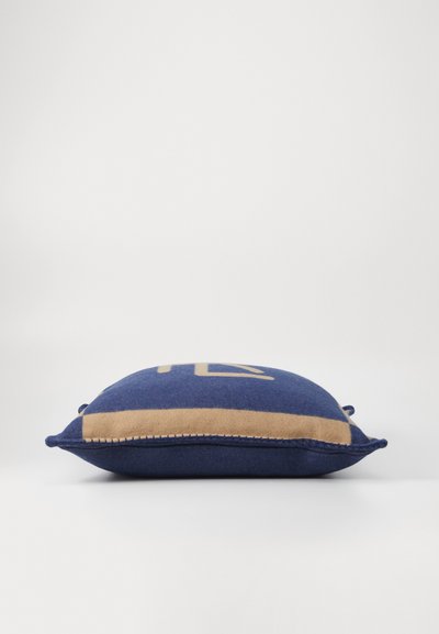 Blauwe en beige decoratieve kussen met een geometrisch ontwerp, zachte textuur en piping langs de randen; vlak profiel met afgeronde hoeken.