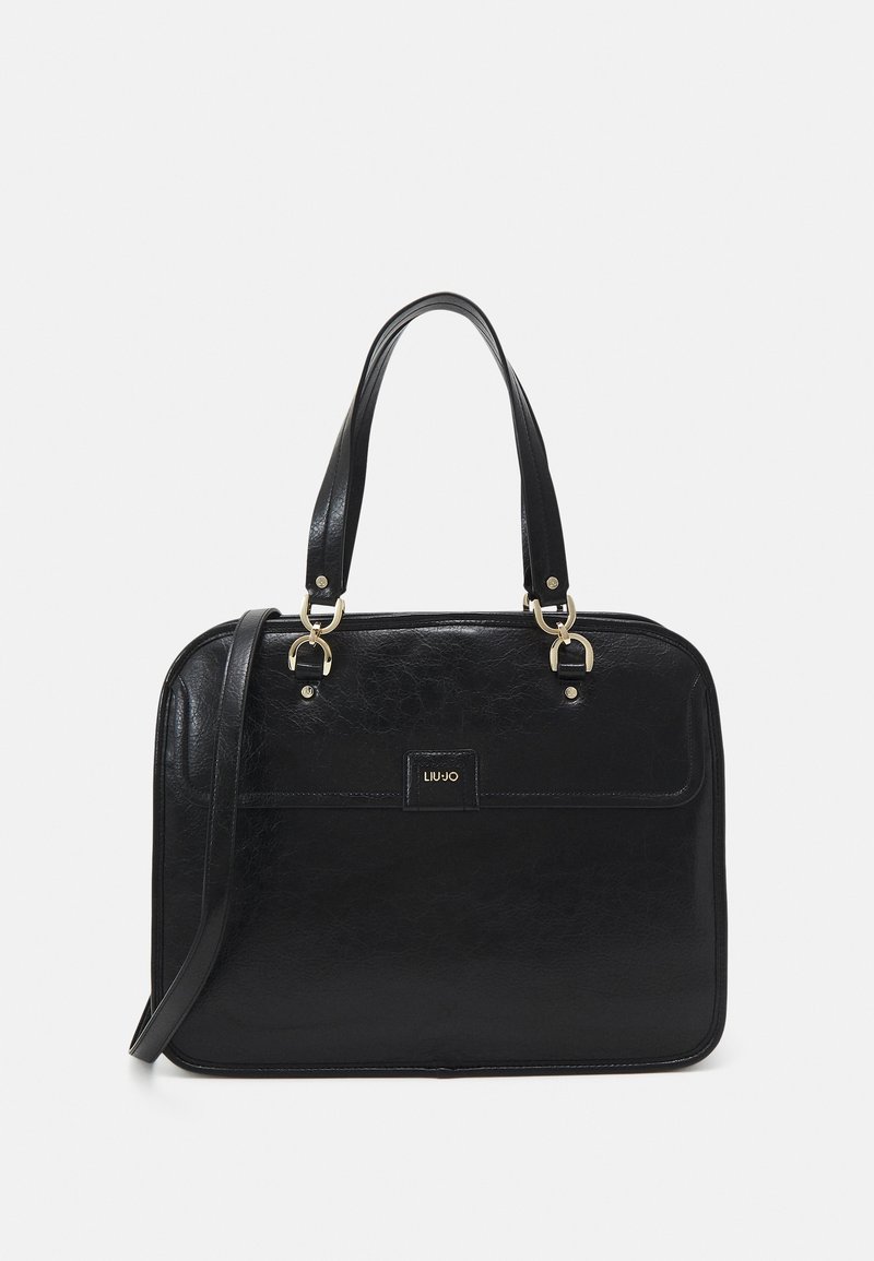 Sac à main en cuir noir avec deux poignées et une bandoulière amovible. Comprend une poche avant et des accents en métal doré. Texture lisse.