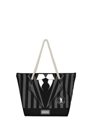 Bolsa de mano en blanco y negro diseñada como un esmoquin, con rayas verticales, un cuello blanco y una corbata, asas de cuerda beige y detalle del logo.