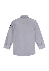 Camicia grigia a maniche lunghe con bottoni, caratterizzata da un colletto classico, orlo arrotondato e un'etichetta nera sulla manica sinistra. Tessuto di consistenza liscia.