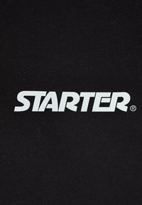 Fekete anyag, amelyen a „STARTER” márkanevünk vastag, fehér betűkkel, regisztrált védjegy szimbólummal van feltüntetve. Texturált felület.